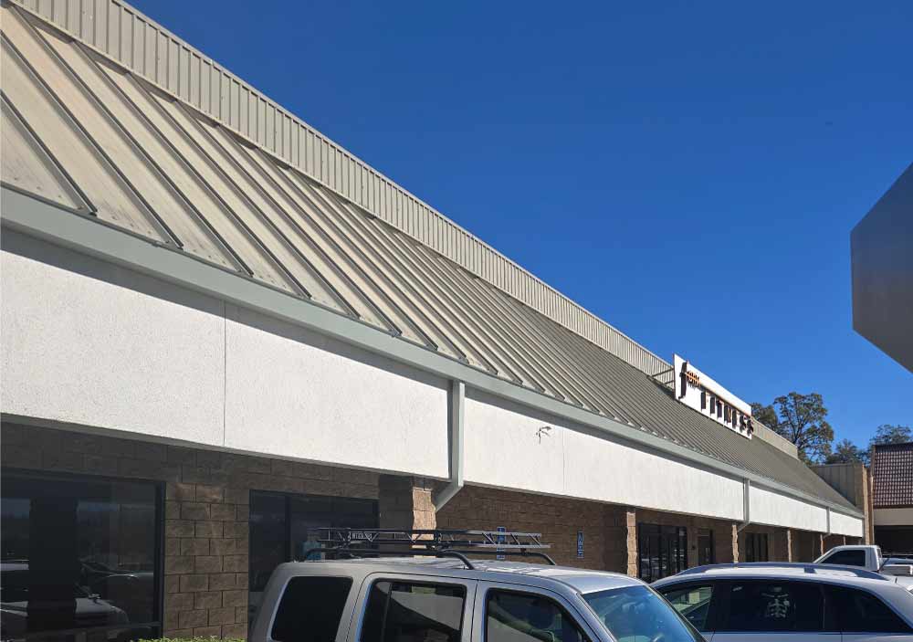 Close-up view of a professional white plaster finish on a commercial building fascia, showcasing a clean and inviting look for a local fitness center remodel.