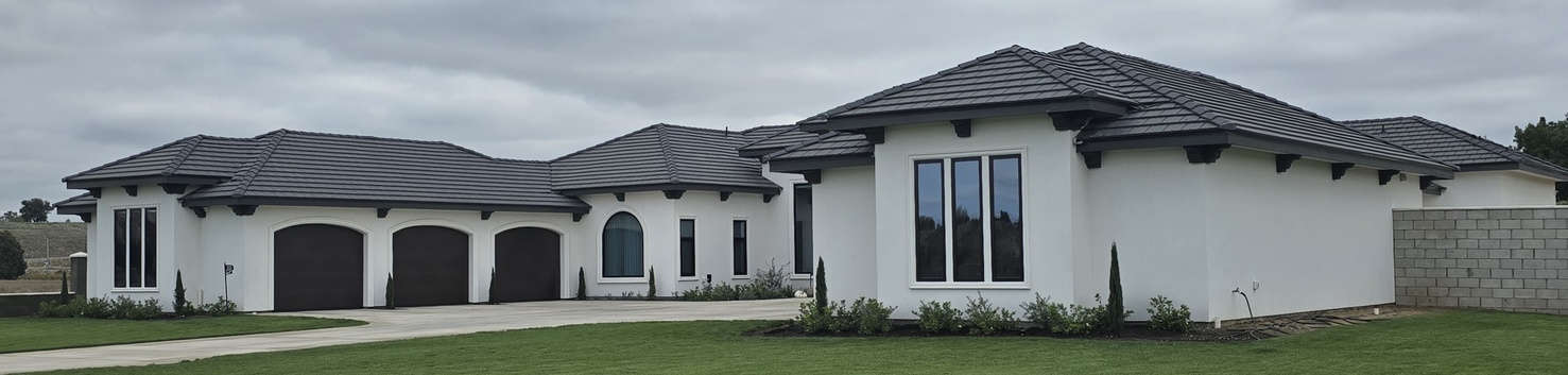 Side profile of a luxury residential property highlighting the uniform application of exterior stucco on expansive walls and integrated architectural gables.